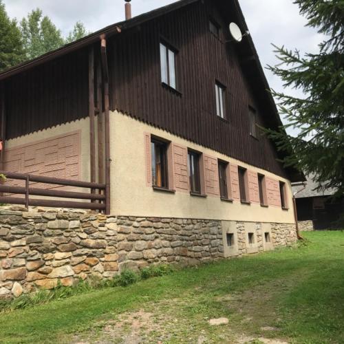 a large building with a stone wall and windows at Sněženka in Dolní Morava