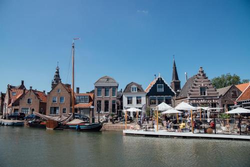 a group of buildings next to a body of water at Harbour Suites Boutique Hotel in Monnickendam