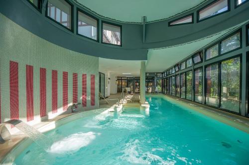- une grande piscine dans un bâtiment doté de fenêtres dans l'établissement Hôtel Miléade Les Pléïades La Baule, à La Baule