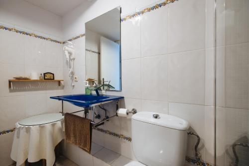 een badkamer met een toilet en een blauwe wastafel bij Apartamento Las Brisas II in Valencina de la Concepción