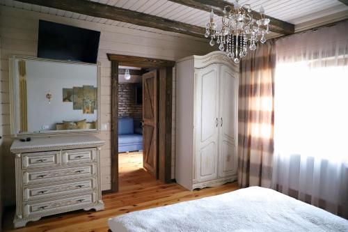 a bedroom with a white dresser and a chandelier at Apple House in Mykulychyn
