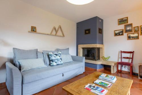 uma sala de estar com um sofá e uma lareira em La Bergerie apartment in an old farmhouse! em Nâves-Parmelan