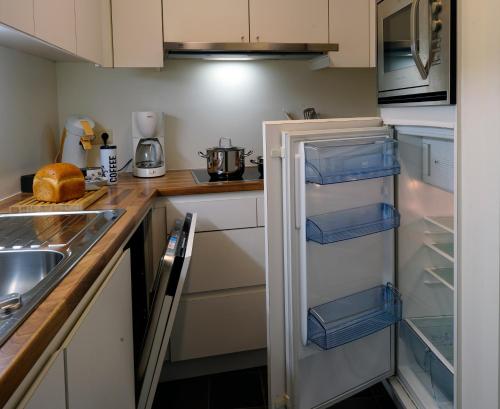a kitchen with a refrigerator with its door open at Apartments Ypres in Ypres
