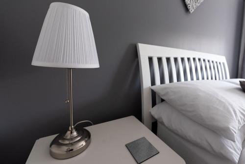 a lamp sitting on a table next to a bed at Riverside Stays, Shefford in Shefford