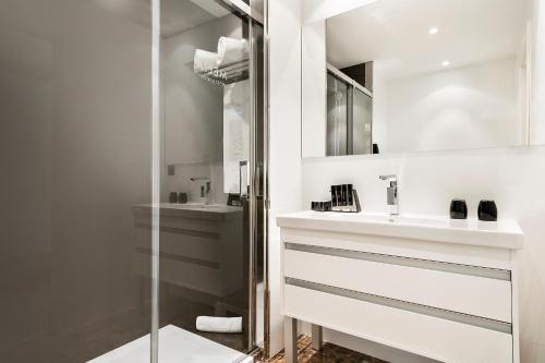 
a bathroom with a mirror, sink, and bathtub at Melia Sitges in Sitges
