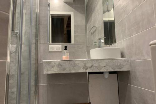 une salle de bain avec un lavabo et un miroir dans l'établissement CHARMING Saint GERMAIN ODEON LUXEMBOURG, à Paris