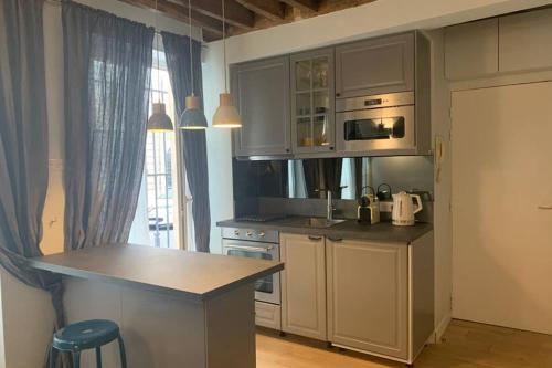 une cuisine avec des armoires blanches et un comptoir dans l'établissement CHARMING Saint GERMAIN ODEON LUXEMBOURG, à Paris