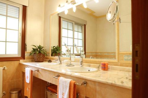 ein Badezimmer mit einem Waschbecken und einem großen Spiegel in der Unterkunft Casamary Planta Alta in Pontevedra