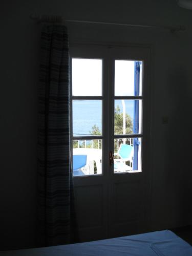 a bedroom door with a view of the ocean at Tatsis Apartments in Masouri