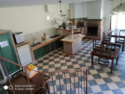 kuchnia z zielonymi szafkami oraz stołem i krzesłami w obiekcie B&B Villagiulia w mieście Sogliano Cavour