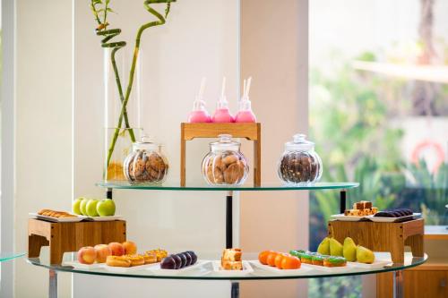 a shelf with different types of pastries on it at Holiday Inn Muscat AlSeeb by IHG in Muscat