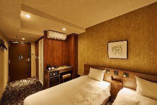 una camera da letto con un grande letto bianco e una scrivania di Welina Hotel Premier Nakanoshima EAST ad Osaka