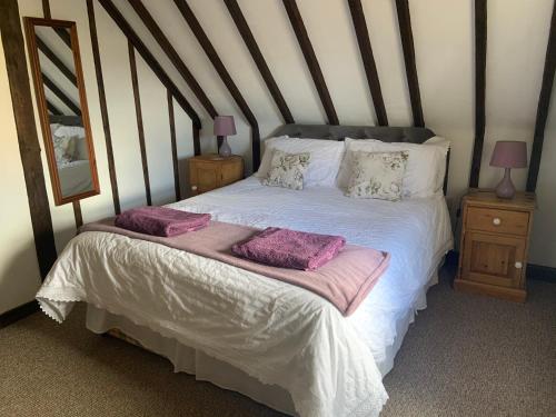 uma cama com duas almofadas num quarto em Rose Cottage em Rye