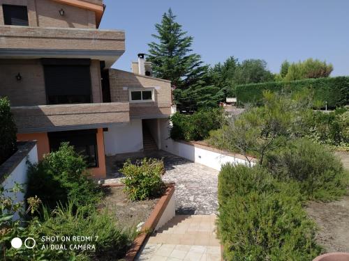 a view of a house with bushes and trees at B&B Villagiulia in Sogliano Cavour