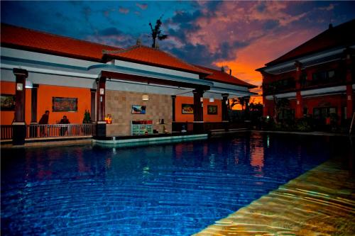 a large swimming pool in front of a building at Swastika Bungalows in Sanur