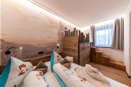 Pokój z łóżkiem i ścianą z obrazem w obiekcie Sonnleiten Sonnenadler 4 w mieście Collepietra