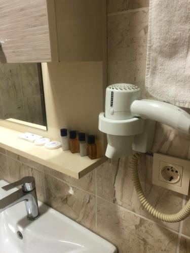 Avesis Hotel في نصيبين: حمام مع حوض وهاتف على الحائط