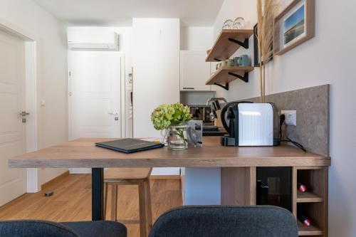a kitchen with a wooden table with a microwave at Apartments Galumbo - bleiben & genießen in Illmitz
