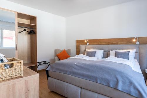 a bedroom with a large bed with a wooden headboard at Apartments Galumbo - bleiben & genießen in Illmitz