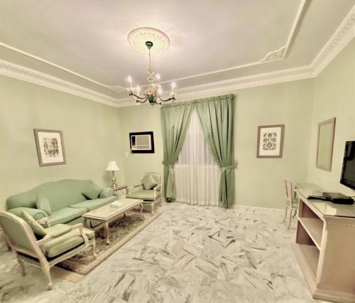 a living room with a couch and chairs and a chandelier at Rotana Residence Apartments in Jeddah