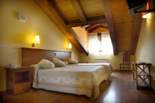 a bedroom with a large bed and a wooden ceiling at Hotel Restaurante Santa Lucía in La Magdalena