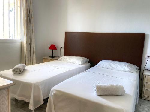 ロス・クリスティアーノスにあるTenerife Los Cristianos Dinastia Complexのベッドルーム1室(白いシーツとヘッドボード付きのベッド2台付)