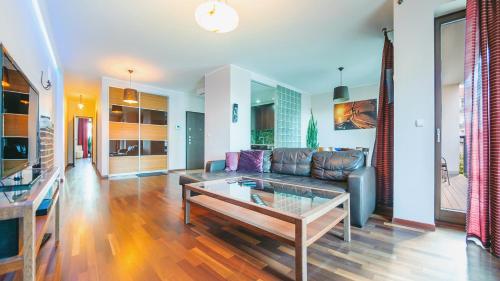 a living room with a couch and a coffee table at Apartamenty Sun & Snow Szafarnia in Gdańsk