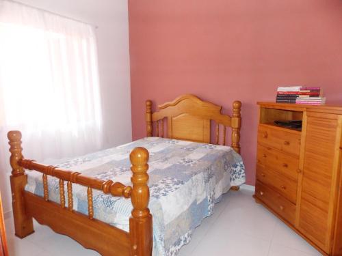 a bedroom with a wooden bed and a wooden dresser at Casa Vila Dom Pedro in Paraty