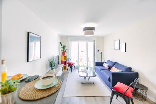 un salon avec un canapé bleu et une table dans l'établissement L'Idéal- Cité des Congrès, à Nantes