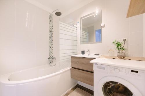 une salle de bain blanche avec une machine à laver à l'intérieur dans l'établissement L'Idéal- Cité des Congrès, à Nantes