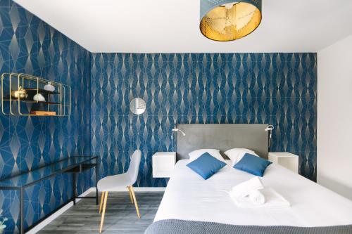 - une chambre avec un lit et un mur bleu dans l'établissement L'Idéal- Cité des Congrès, à Nantes