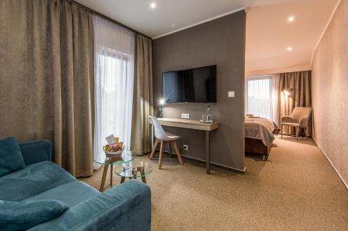 a hotel room with a blue couch and a bed at Penzion ZENIT in Prešov