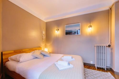- une chambre avec un lit blanc et 2 serviettes dans l'établissement L'Imperti'Nantes- T3bis de Standing, à Nantes