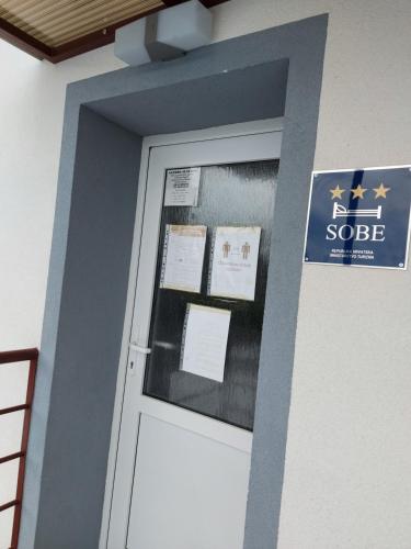 a door in a building with a sign on it at SOBE RIM BREZJE DRAVSKO in Cestica