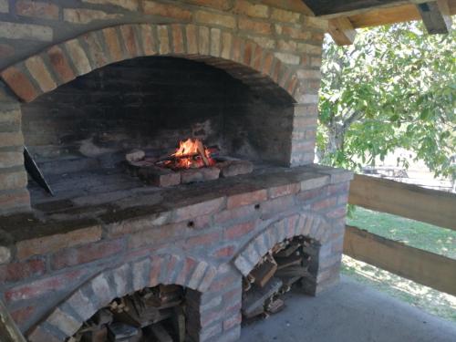 a brick oven with a fire in it at Kuća za odmor Atar in Bartolovci
