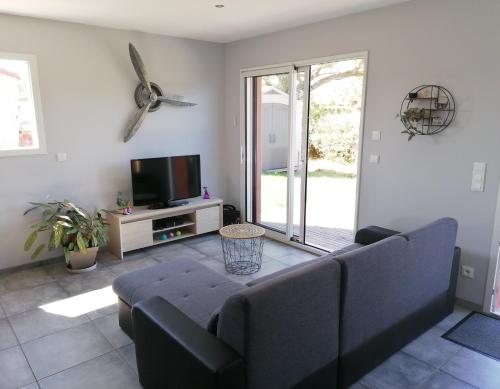 a living room with a couch and a tv at La Petite Maison in Ouches