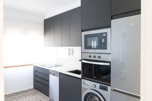 a kitchen with a microwave and a washer and dryer at Town Hall in Bilbao