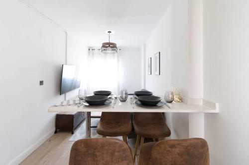 a dining room with a table with bowls and chairs at Town Hall in Bilbao