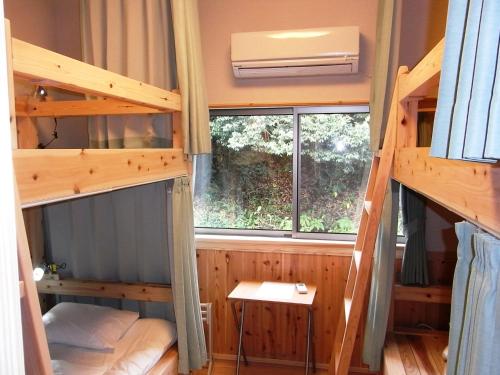 a room with two bunk beds and a window at Guest House Yakushima in Yakushima