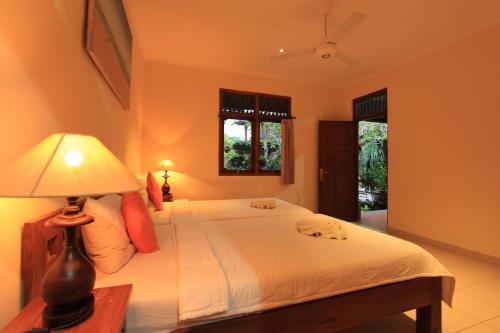 a bedroom with a bed with a lamp on a table at Duana's Homestay in Ubud