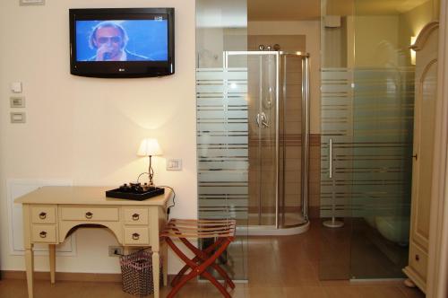 uma casa de banho com chuveiro e uma televisão na parede em Hotel Piccolo Principe em Villongo SantʼAlessandro