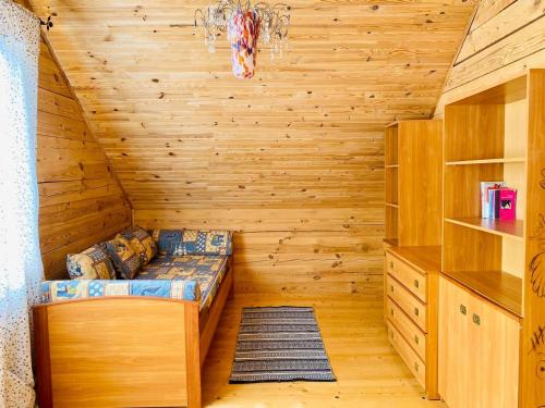 a log cabin with a bed in a room at Eco house in Szack