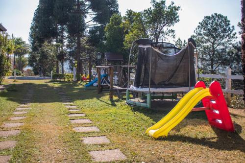 a playground with a slide and a swing set at Pousada Sonho Meu in Itanhandu