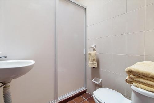 y baño con ducha, aseo y lavamanos. en Cómoda suite Céntrica El Prado A37, en Casa Blanca La Corregidora