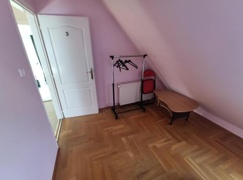 a room with a staircase with a table and a door at Apollo Vendégház in Bogács