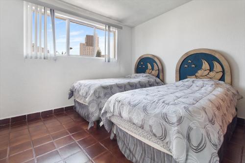 a bedroom with two beds and a window at Cómoda suite Céntrica El Prado A37 in Casa Blanca La Corregidora