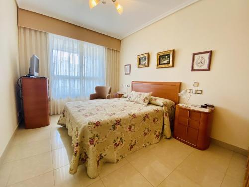 sypialnia z łóżkiem i telewizorem w obiekcie A908 - Coruña w mieście Villajoyosa