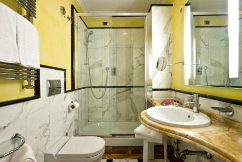 uma casa de banho com um lavatório, um chuveiro e um WC. em Suite Opera Rooms em Roma