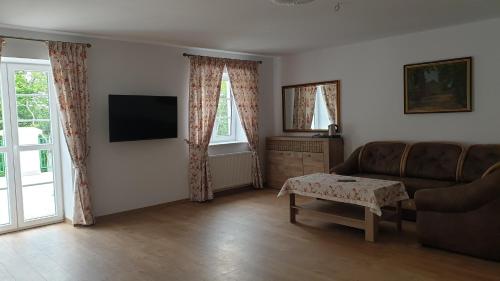 a living room with a couch and a tv at Dwór nad jeziorem w Bieniaszach in Miłakowo