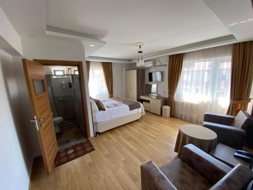 a living room with a bed and a couch at Figen Hotel in Çanakkale
